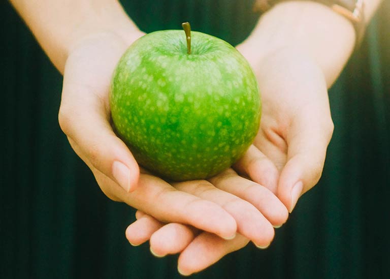 Händer som håller ett hälsosamt äpple. Utbilda dig till Hälsoinspiratör och hälsopedagog på Tärna folkhögskola.