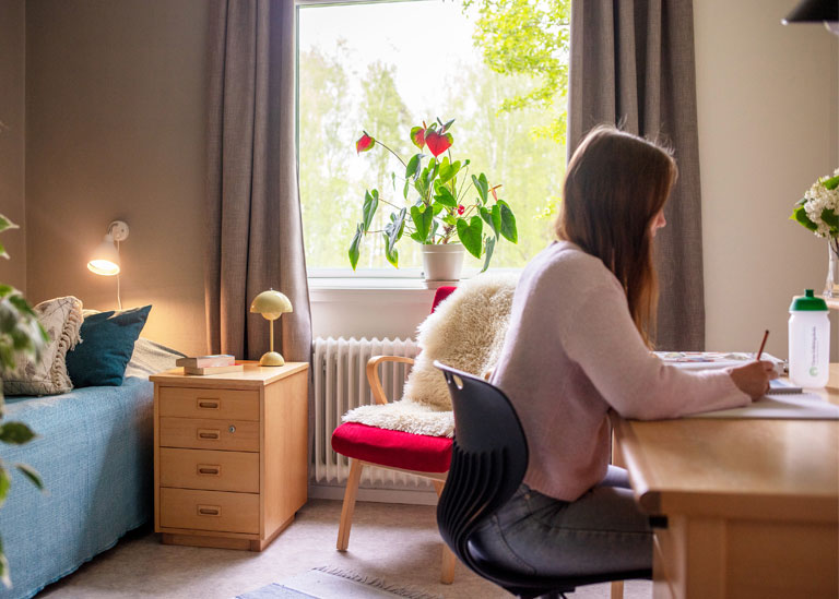 En tjej som sitte och pluggar vid sitt skrivbordpå Tärna folkhögskola
